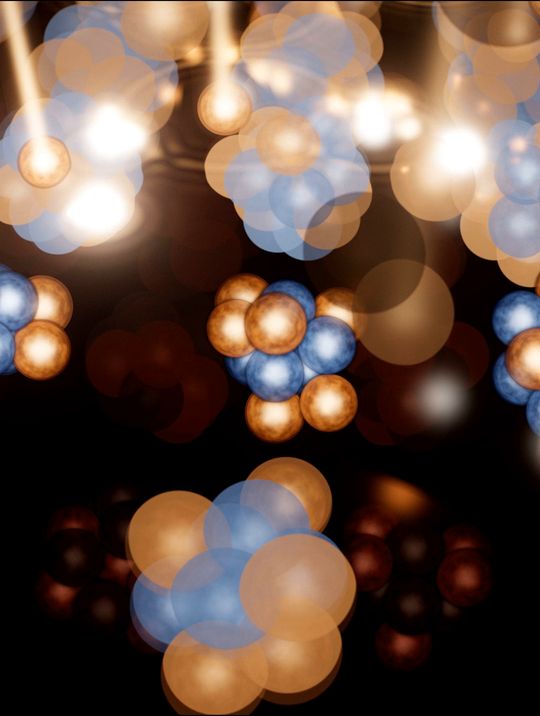 Atomic nuclei, clusters of blue and amber spheres, packed in a glowing fog